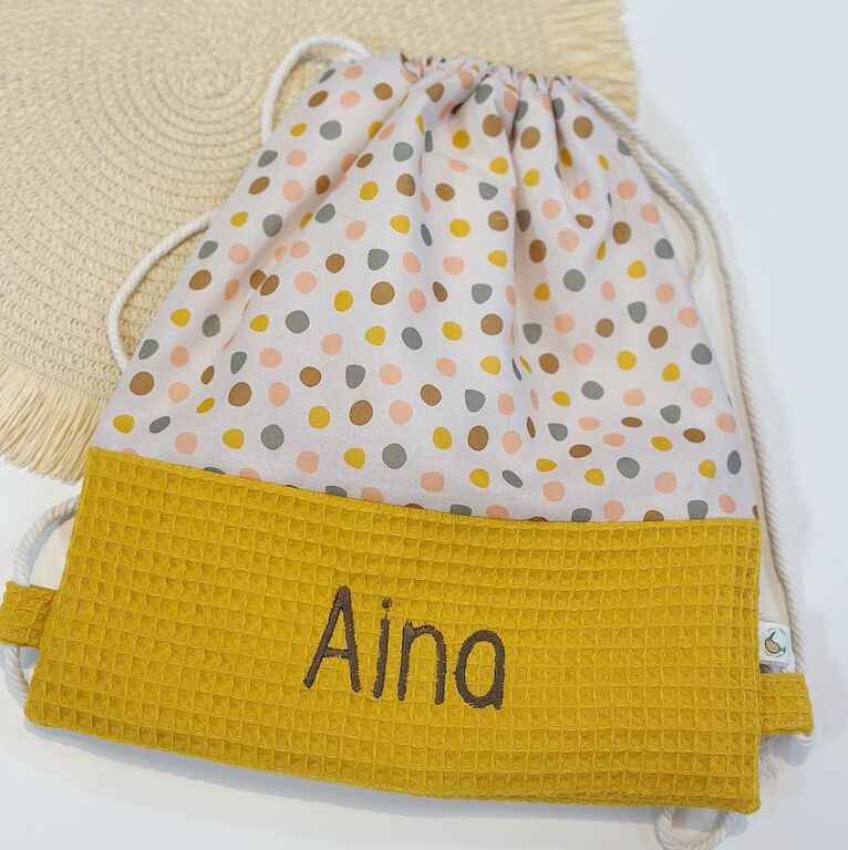Mochila saco infantil con cuerdas de tela topos de colores y gofre mostaza